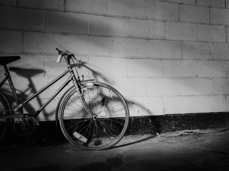 an old bicycle leaning against a wall next to a cement wall