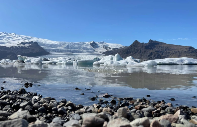 icebergs that are melting off on the surface of water