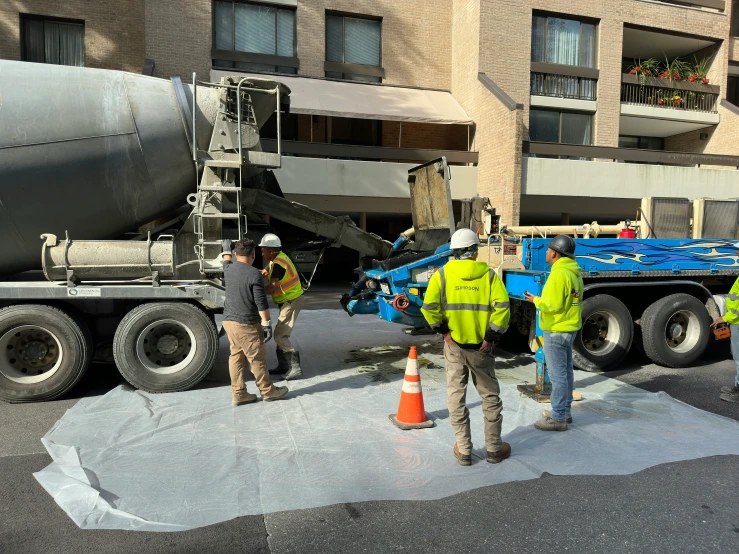 people on street next to concrete mixer near building