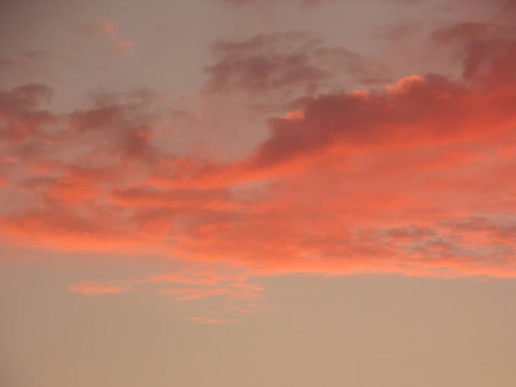 airplane at sunset with pink clouds above it