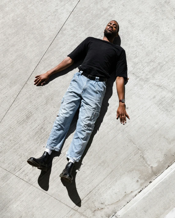 a man that is laying on some cement