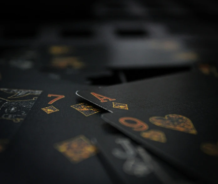 four black playing cards have different patterns and numbers on them