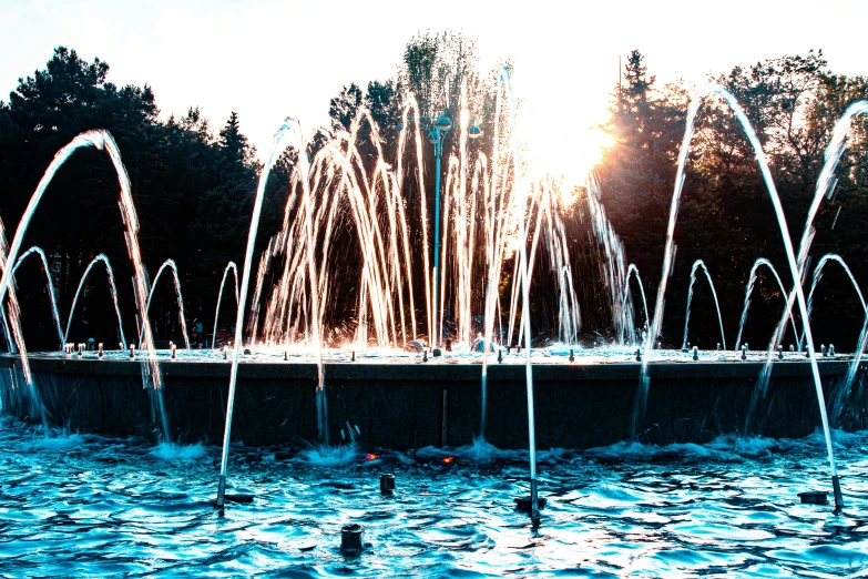 a pond with multiple fountain spouts spewing water in the air