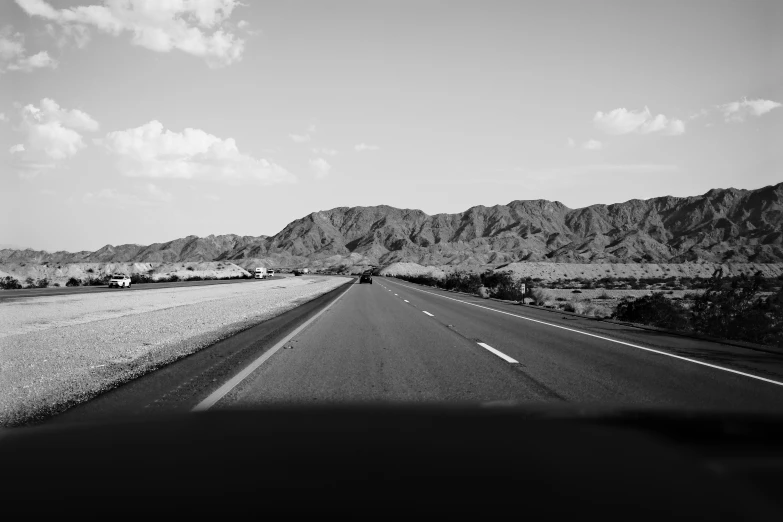 an empty highway near mountains in the desert