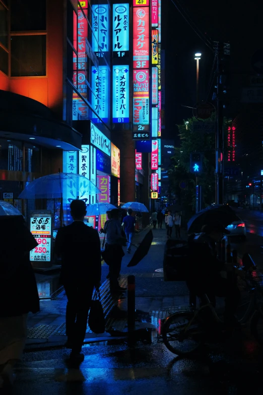 some people are standing on a street with umbrellas