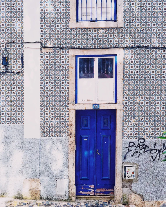 a blue door on an old building next to a wall