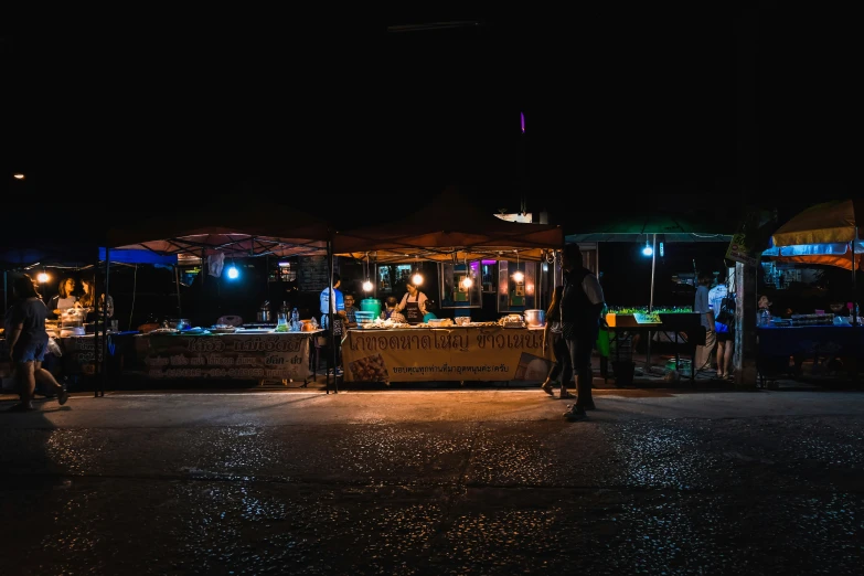 vendors are gathered on the street at night