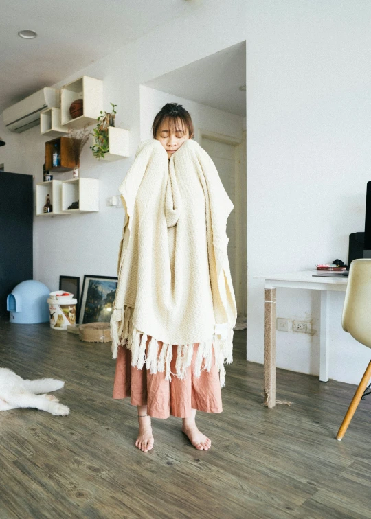 an asian woman holds a blanket in a living room