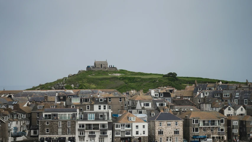 buildings near the hill are lined with green grass