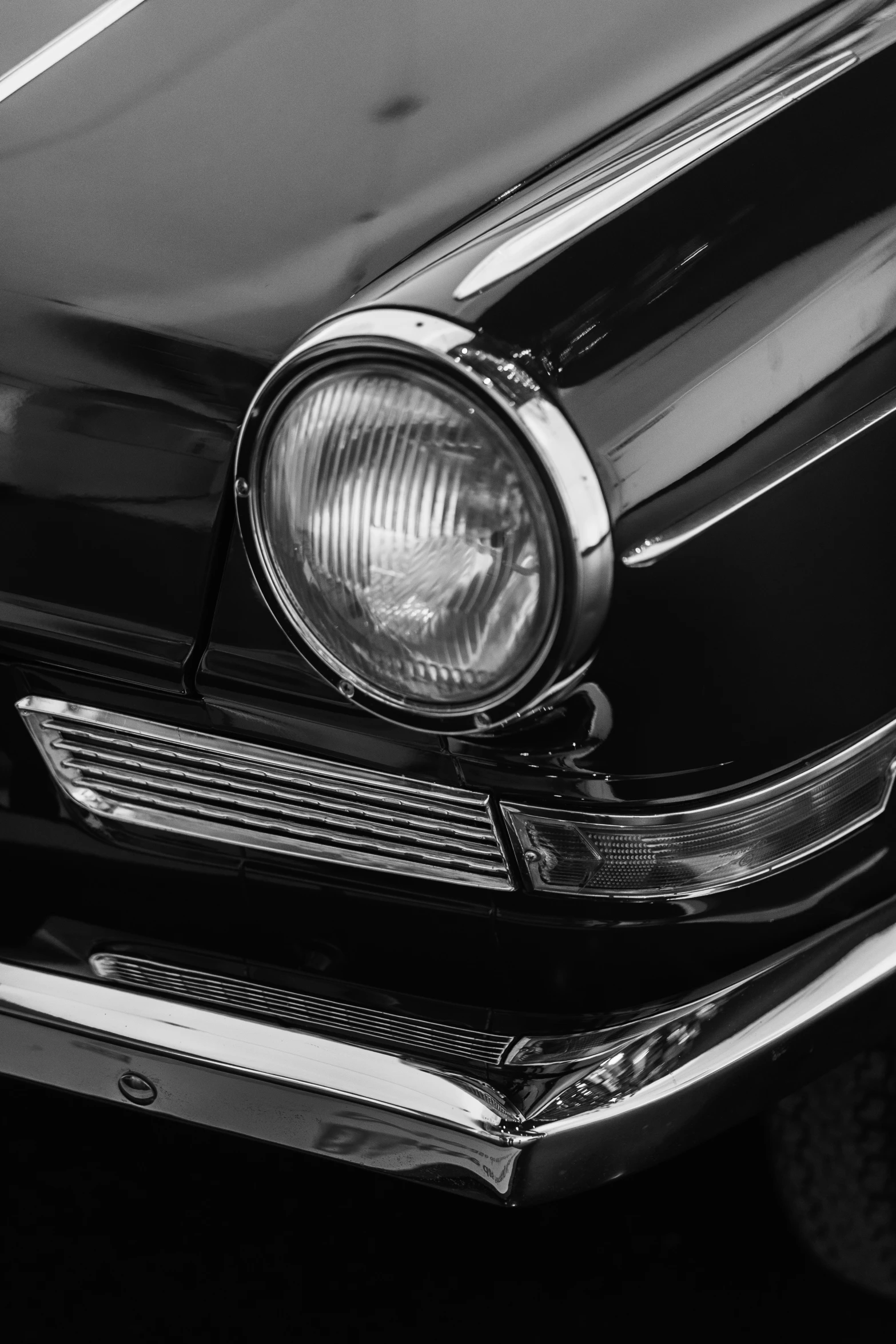 the headlights on a black classic car in the day