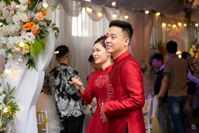 a couple posing for a po in front of some floral decorations