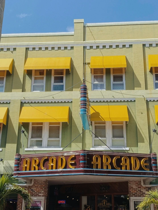 an old movie theater sign in front of yellow building