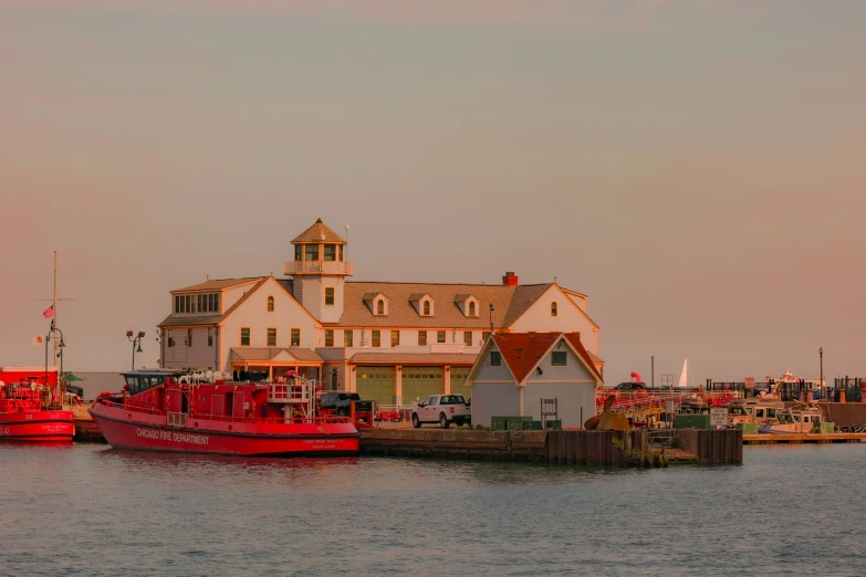 a red boat parked next to a large white house