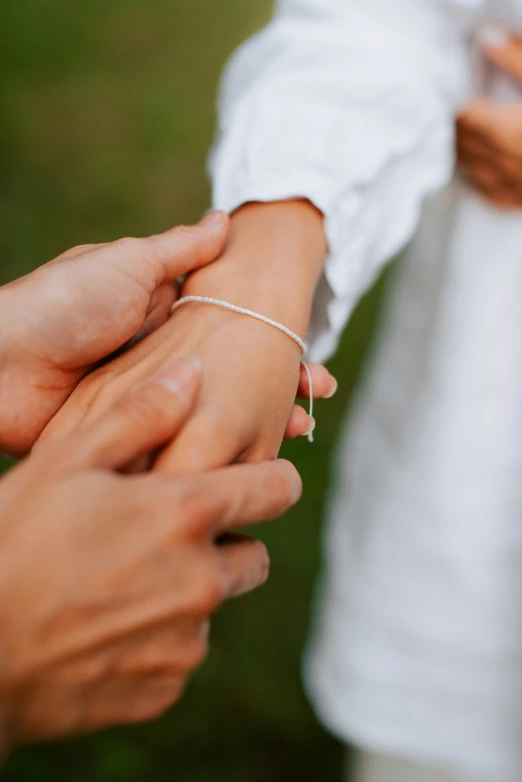 two people are holding hands together while one person holds another