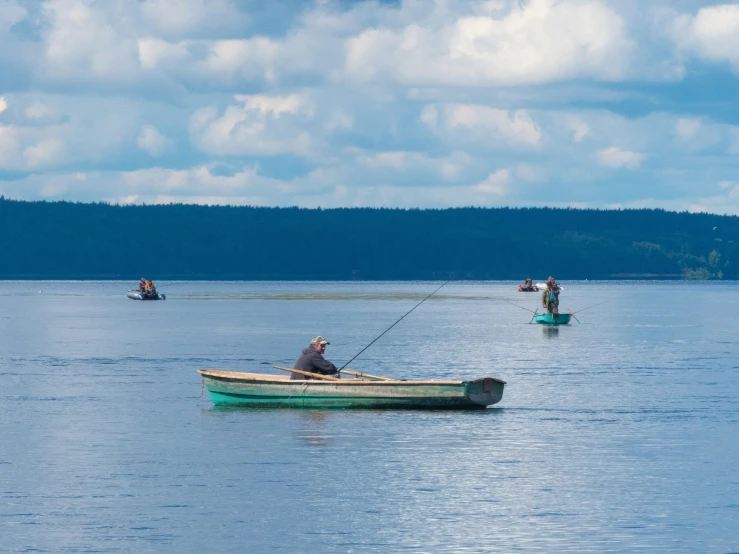 two men are fishing in a boat on the lake