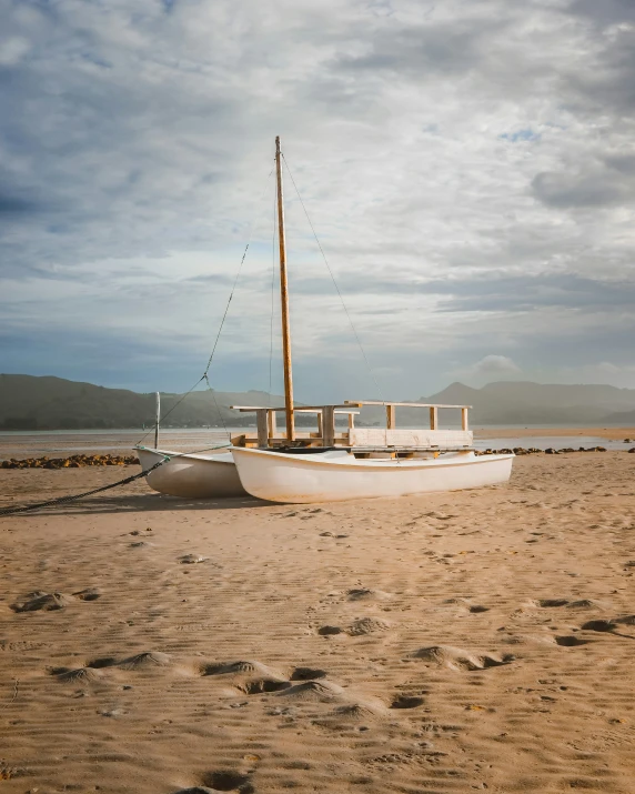 the sailboat sits on the beach next to the ocean