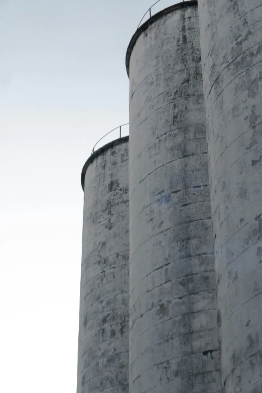 a red stop sign in front of grain silos