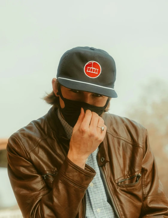 a man wearing a hat with a red badge on his face