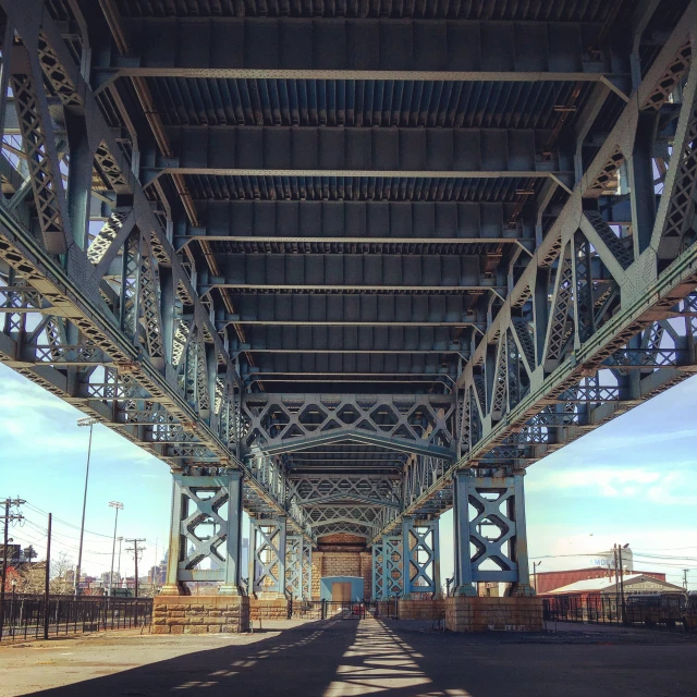 the underside of an elevated highway overpass against the blue sky