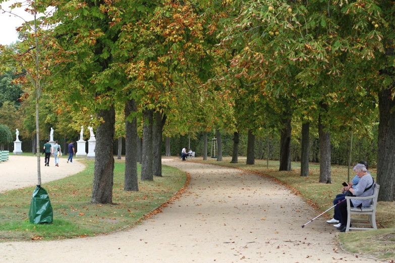 an older lady sitting in a white chair in the middle of a walkway