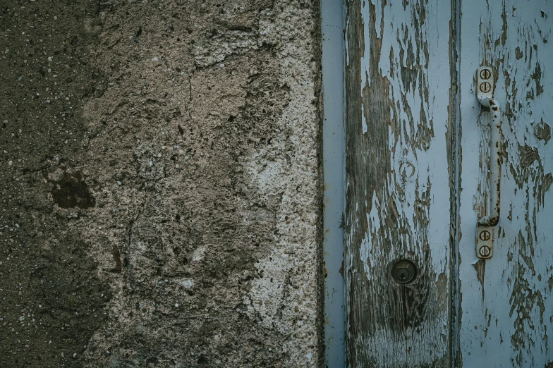 weathered wooden door next to a ed wall