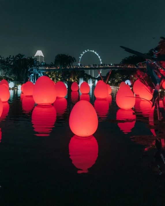 a number of large illuminated balloons in the water