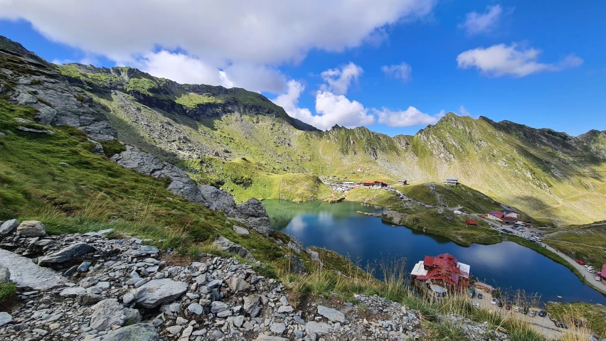 a mountain with a very steep hillside and a small lake with lots of water