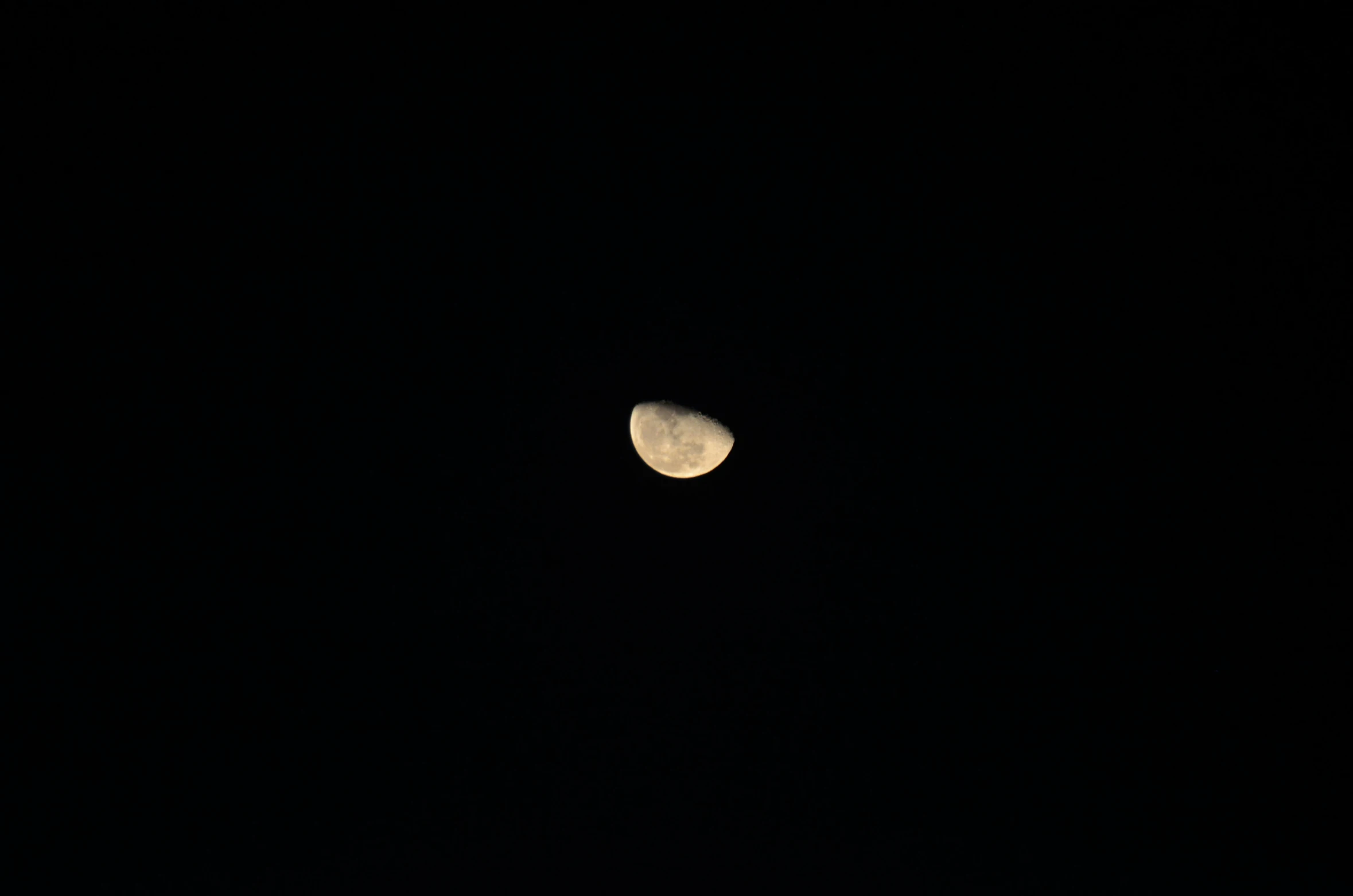 an empty half moon seen through a black sky