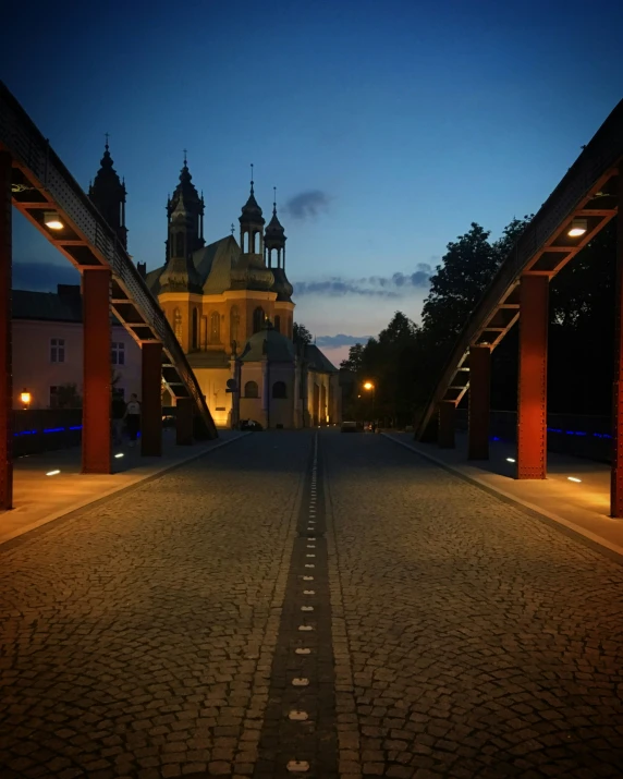 a church is lit up at night while the lights are on