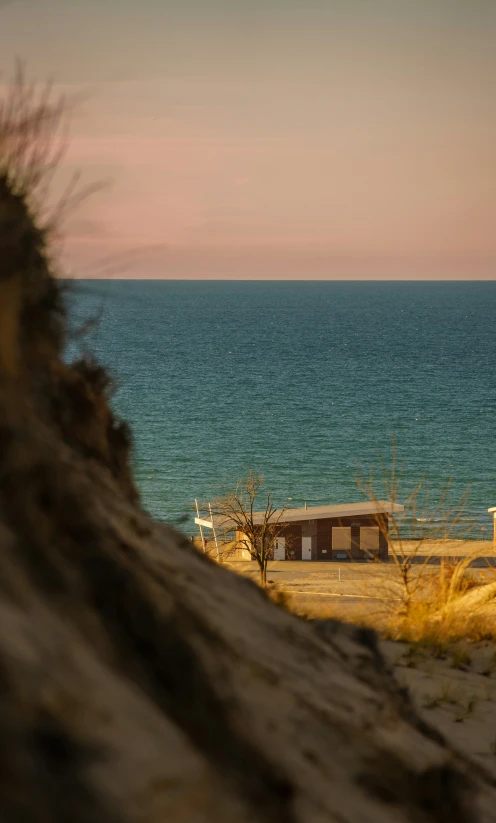 the sky is hazy and pinky over the ocean