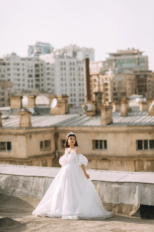 a woman in white dress standing by the top of a building