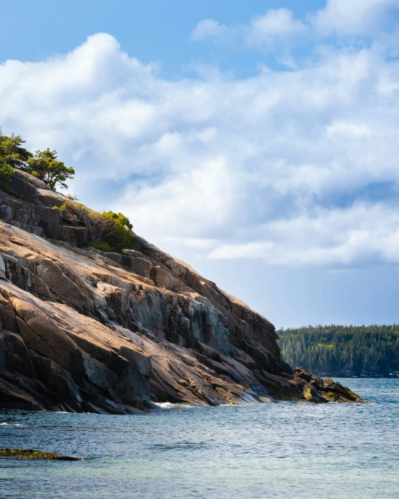 a person standing on a cliff near the water