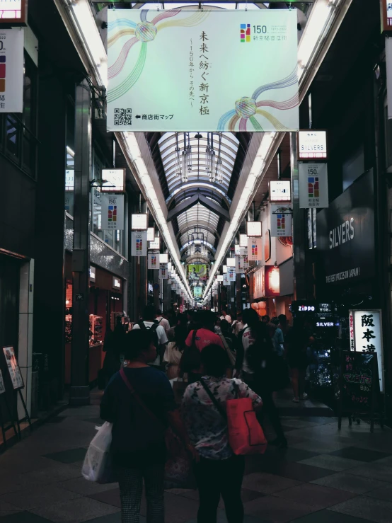 a group of people walking down a street under a sign