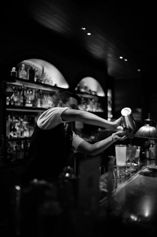 black and white image of man with hat at bar