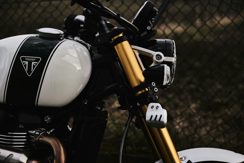 a motorcycle with a black and white seat with a gold handlebar
