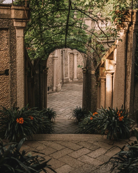 the arch of a brick building is shown with a stone walkway underneath