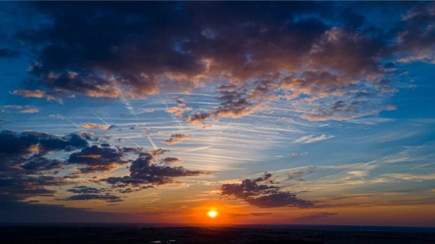 a bright yellow and blue sky and some clouds