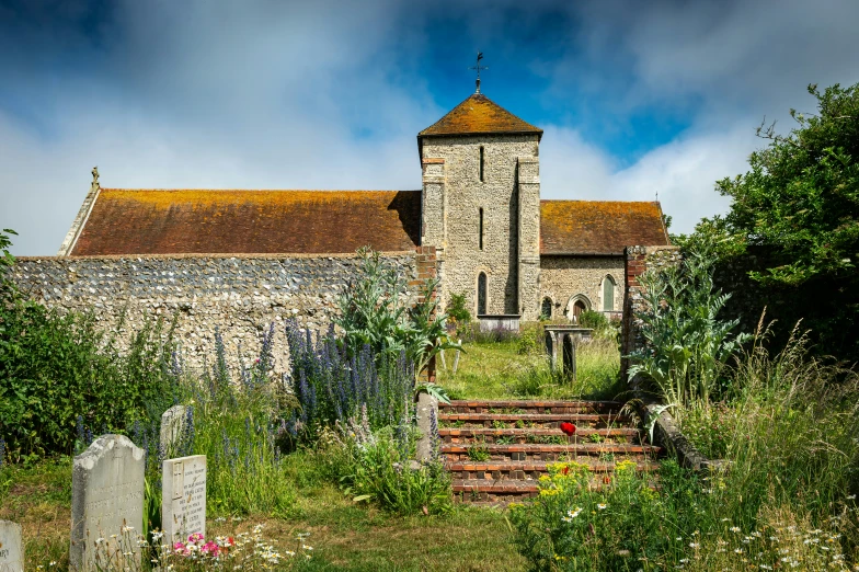 a brick church sits in a grassy, wooded area