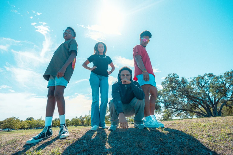 four people in a field with sky and clouds