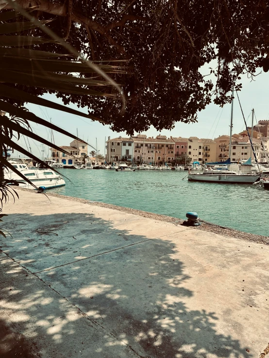 a beach with boats on the water and a city in the background