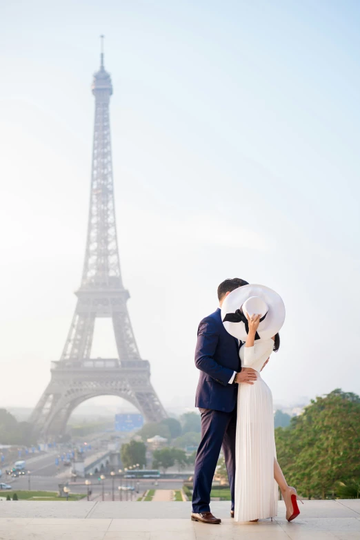 a man and woman holding an umbrella near the eiffel tower