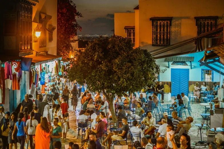 a large crowd of people walking in a city at night