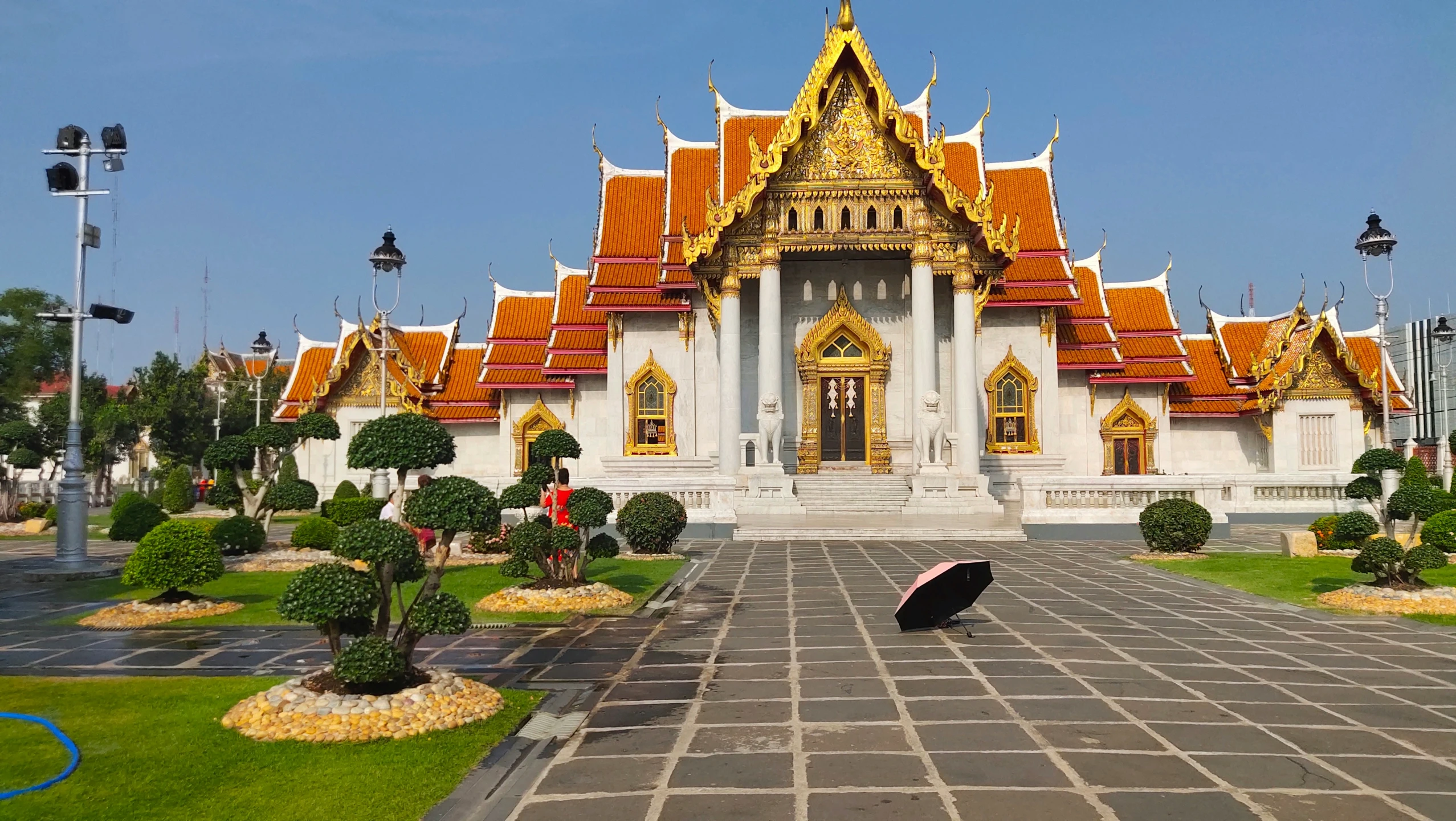 a person stands outside of a temple with their umbrella open