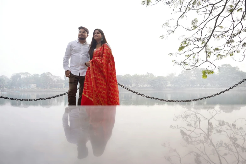 two people dressed in traditional clothing posing on a dock