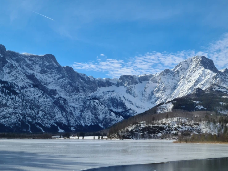 a snowy mountain range looms over a lake