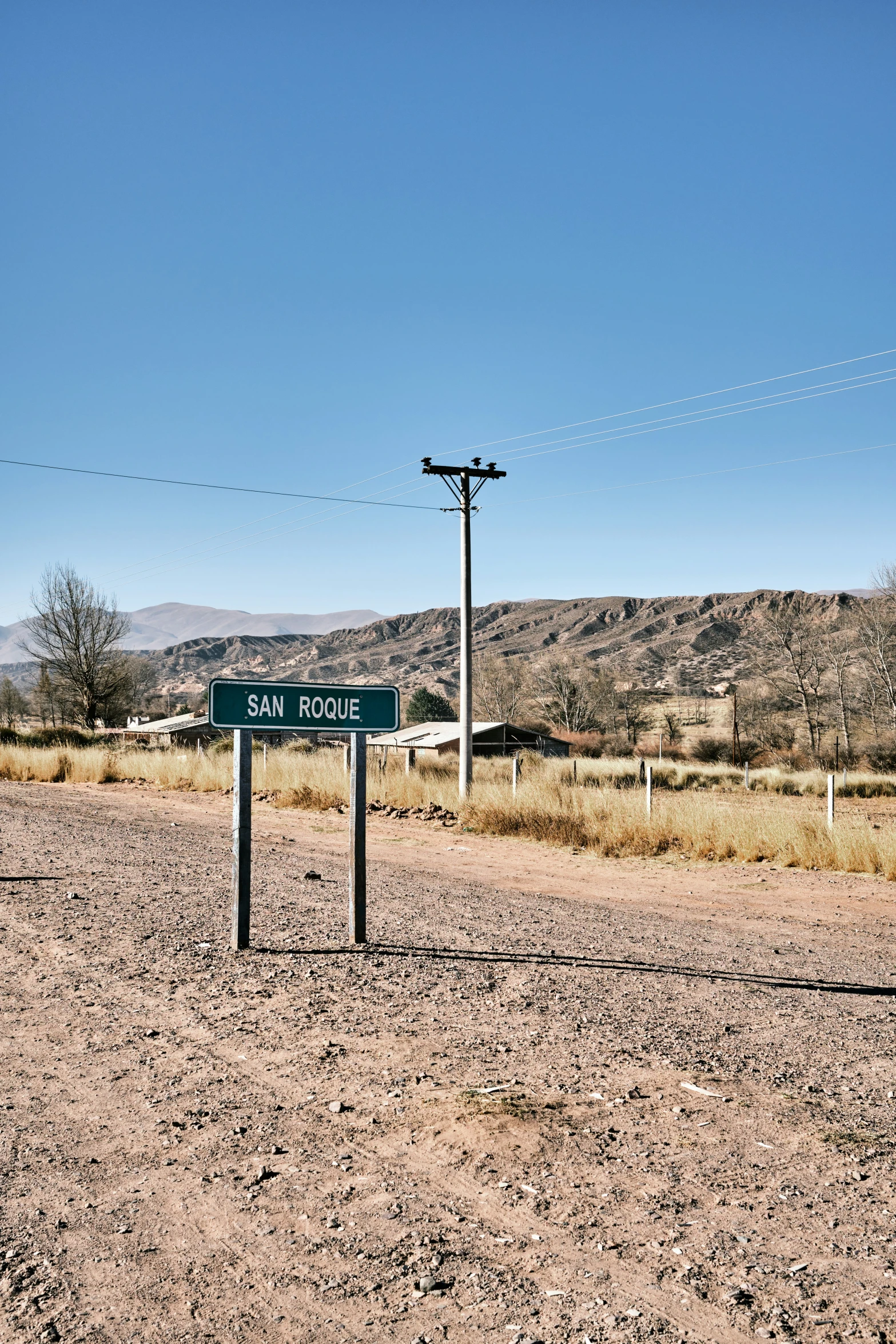 street sign posted in desert with birds flying overhead