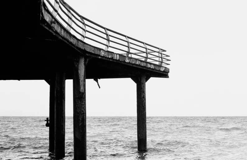 a large wooden pier in the ocean during the day