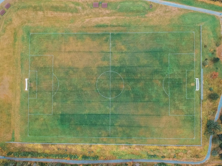 an aerial view of a large field with three buildings on each side