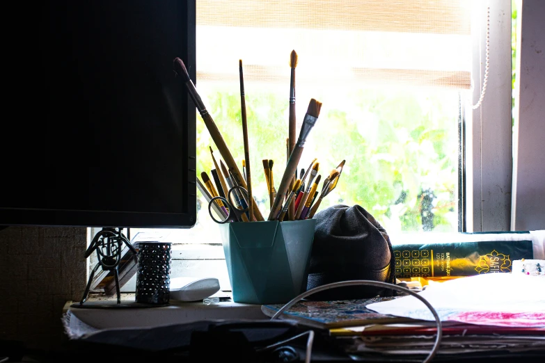 a desk with various assorted pens and pencils