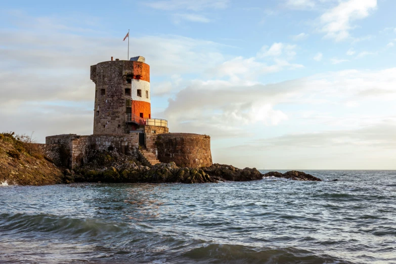 an old water tower in the ocean with waves on it